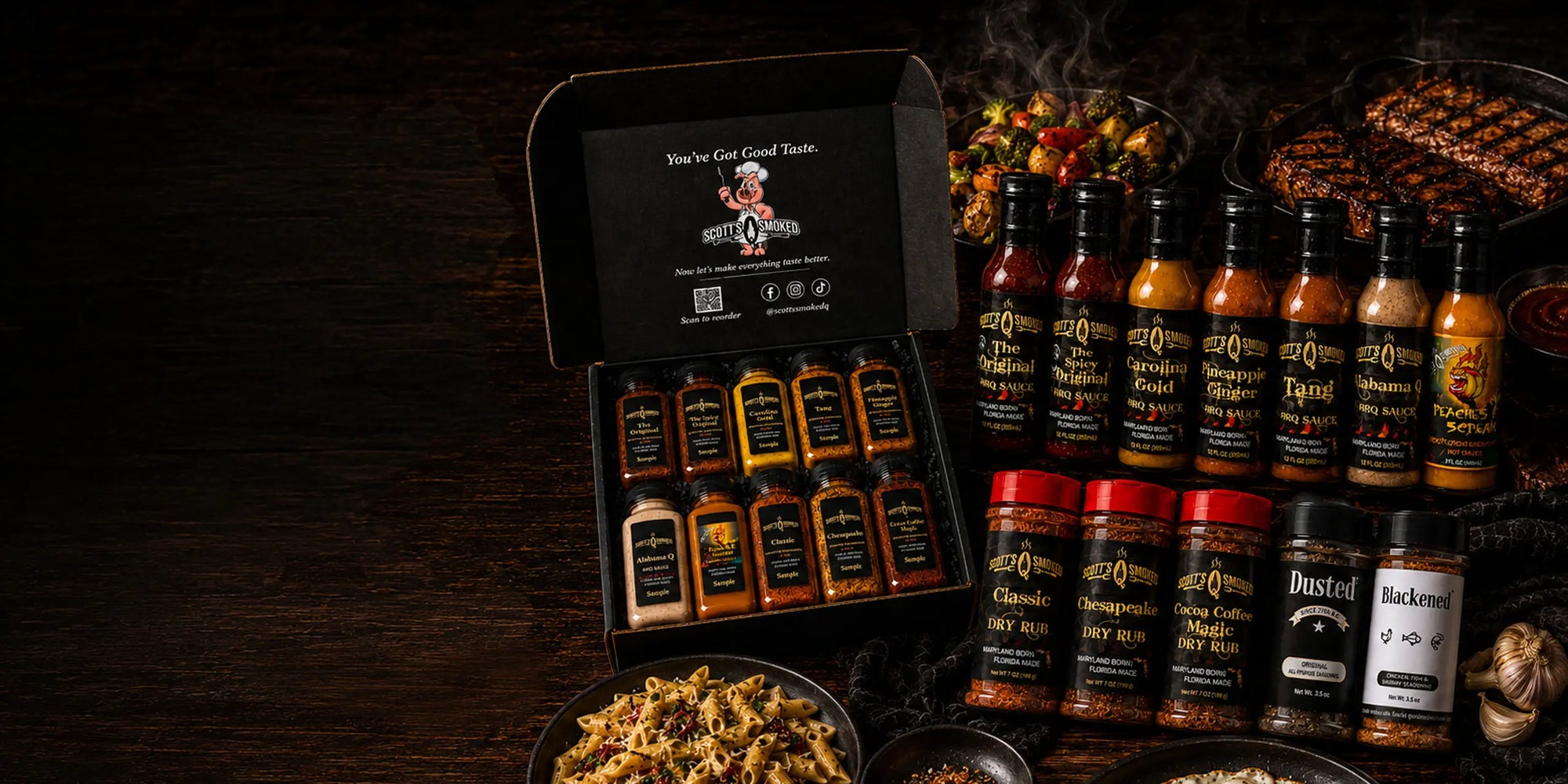 Assorted barbecue sauces, dry rubs, and spices arranged with grilled dishes on a dark wooden table.