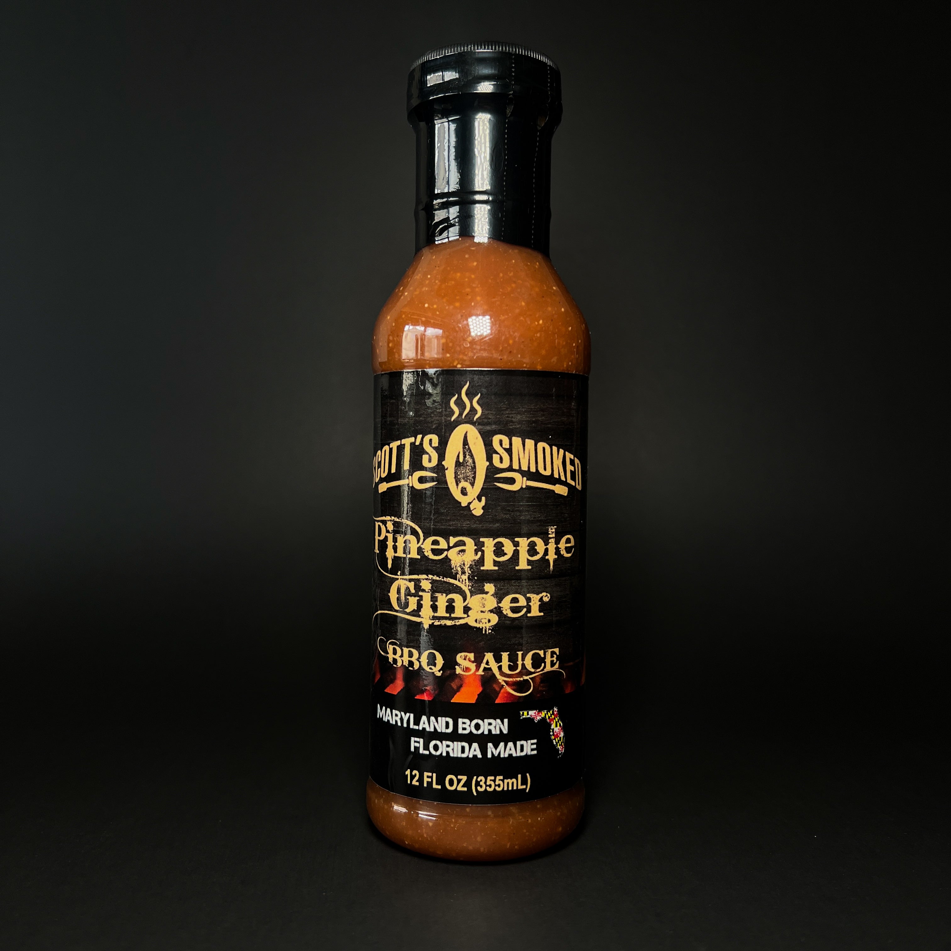 A bottle of Pineapple Ginger BBQ sauce on a dark background.