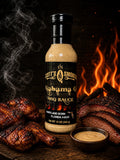 Scott's Smokin' Alabama Q BBQ Sauce bottle with grilled meat and flames in the background.